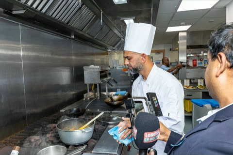 A chef being filmed and interviewed beside the stove during the ARTA cook-off.